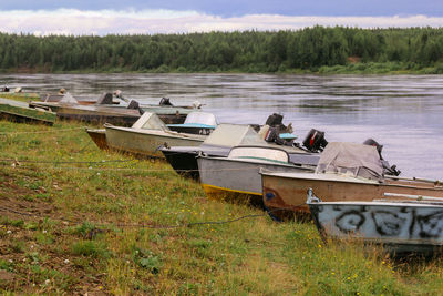 A group of old fishing boats with a motor moored on the river bank