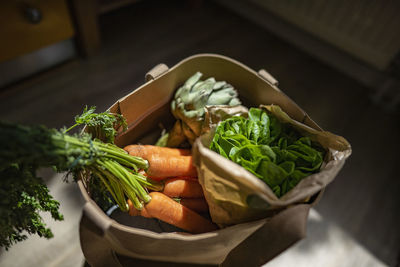 Bag of fresh vegetables at home on sunny day