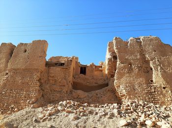 Low angle view of old ruins against clear blue sky