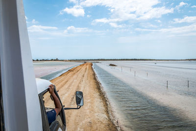 Panoramic view of road by sea against sky