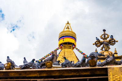 Low angle view of statues on building against sky