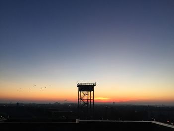 Silhouette built structure against sky during sunset