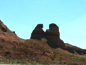 Low angle view of rock formation against clear blue sky