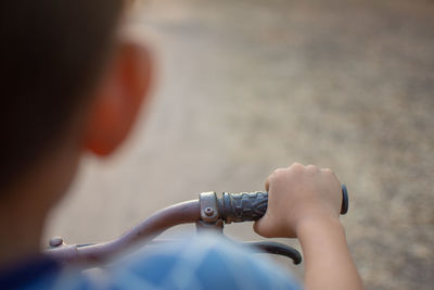 Close-up of boy with bicycle on street