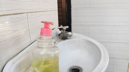 Close-up of hand sanitizer placed at sink in bathroom