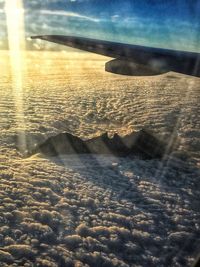 Close-up of airplane flying over sea against sky