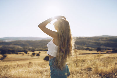 Woman standing on field against sky