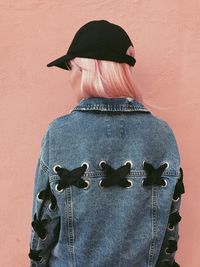 Rear view of woman standing against wall