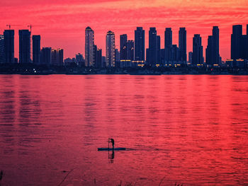 Scenic view of sea and buildings against sky during sunset