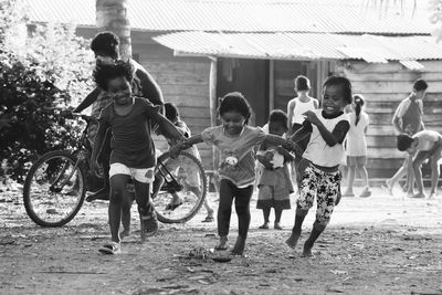 Cute siblings playing on dirt road at village