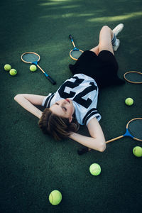 High angle view of tired young woman lying on court