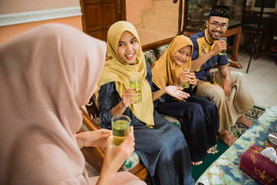 Woman having juice to guests at home