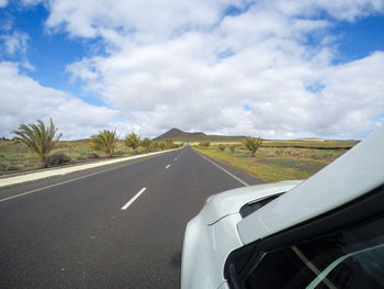 Car on road against cloudy sky