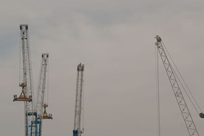 Low angle view of cranes against sky