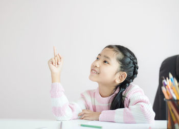 Portrait of smiling girl sitting on table