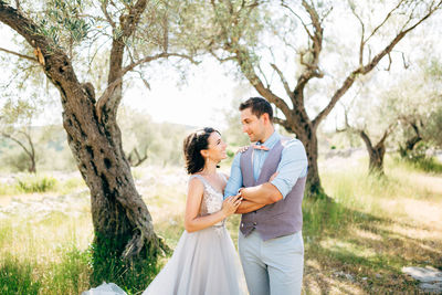 Young couple standing on plant by tree