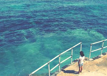 Rear view full length of girl standing by sea