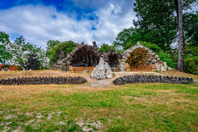 Built structure on landscape against cloudy sky