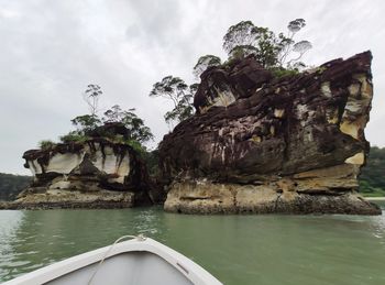 Rock formation by sea against sky