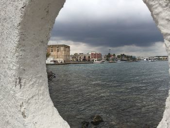 River in city against cloudy sky