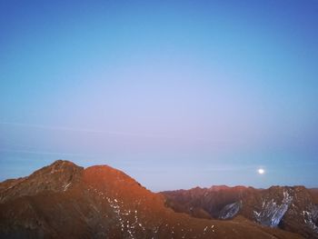 Scenic view of snowcapped mountains against clear blue sky