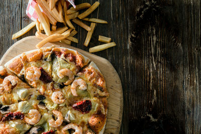 Directly above shot of pizza and french fries on table