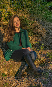 Portrait of beautiful woman sitting on field