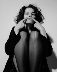 Portrait of young woman wearing hat against white background
