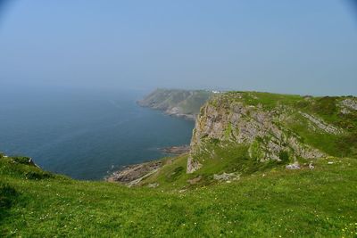 Scenic view of cliffs and sea against sky