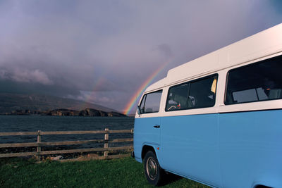 Camper van overlooking a double rainbow