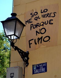 Low angle view of text on street light