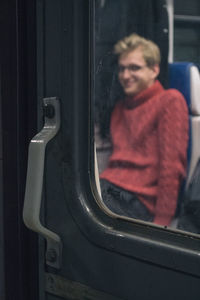 Portrait of smiling mid adult man sitting in bus