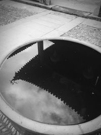 Reflection of sky in puddle on street