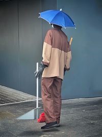 Streetcleaner wearing an umbrella hat