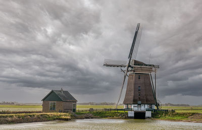 Traditional windmill on field against sky