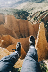 Low section of man relaxing on rock