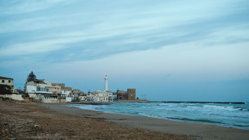 Lighthouse flashing in night in punta secca sicily coast