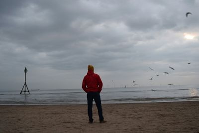 Scenic view of beach against cloudy sky
