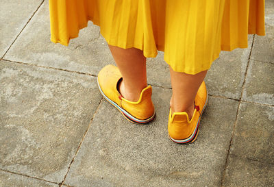 Low section of mature women standing on pavement