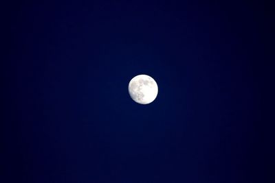 Low angle view of moon against clear blue sky