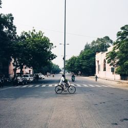 Side view of man cycling on road