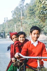 Portrait of smiling friends on bicycle