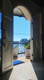 Entrance of building against blue sky seen through window