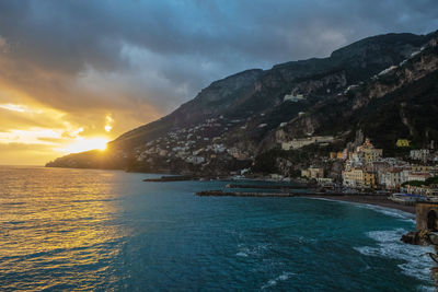 Scenic view of sea against cloudy sky during sunset