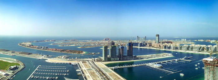 High angle view of city by sea against sky