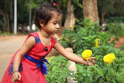 Girl looking away while standing on plant