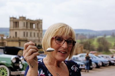 Portrait of woman holding yogurt on spoon