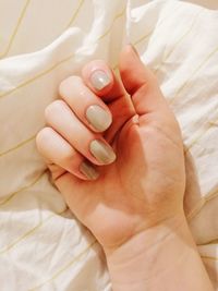 Close-up of woman hand on bed