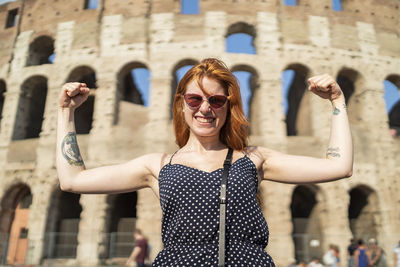 Powerful tourist flexing muscles near famous attraction