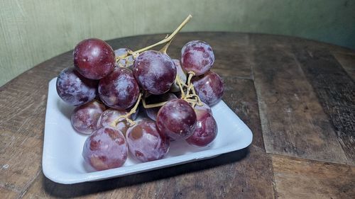 High angle view of grapes in plate on table